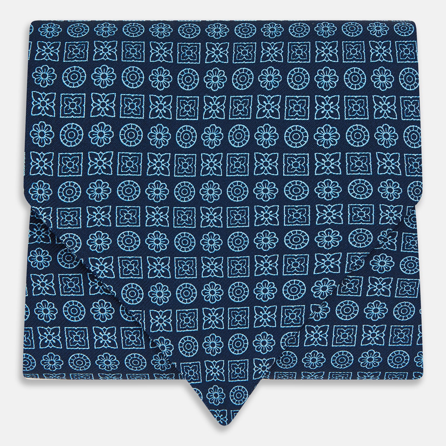Image 1 of product The Turnbull & Asser Dark Navy Floral Tile Pattern Printed Silk Cravat features a British-inspired light blue floral tile design, elegantly displayed on a white background.