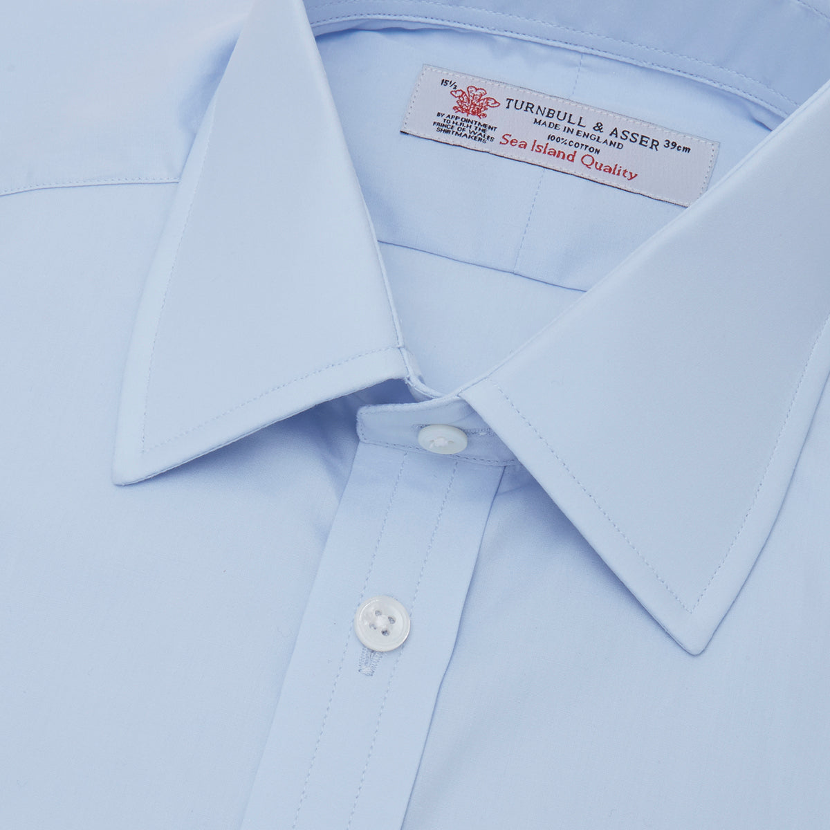 Image 2 of product The Turnbull & Asser Light Blue Sea Island Quality Cotton Shirt features a T&A collar, double cuffs, white buttons, and a quality label inside the collar. Displayed on a plain white background.