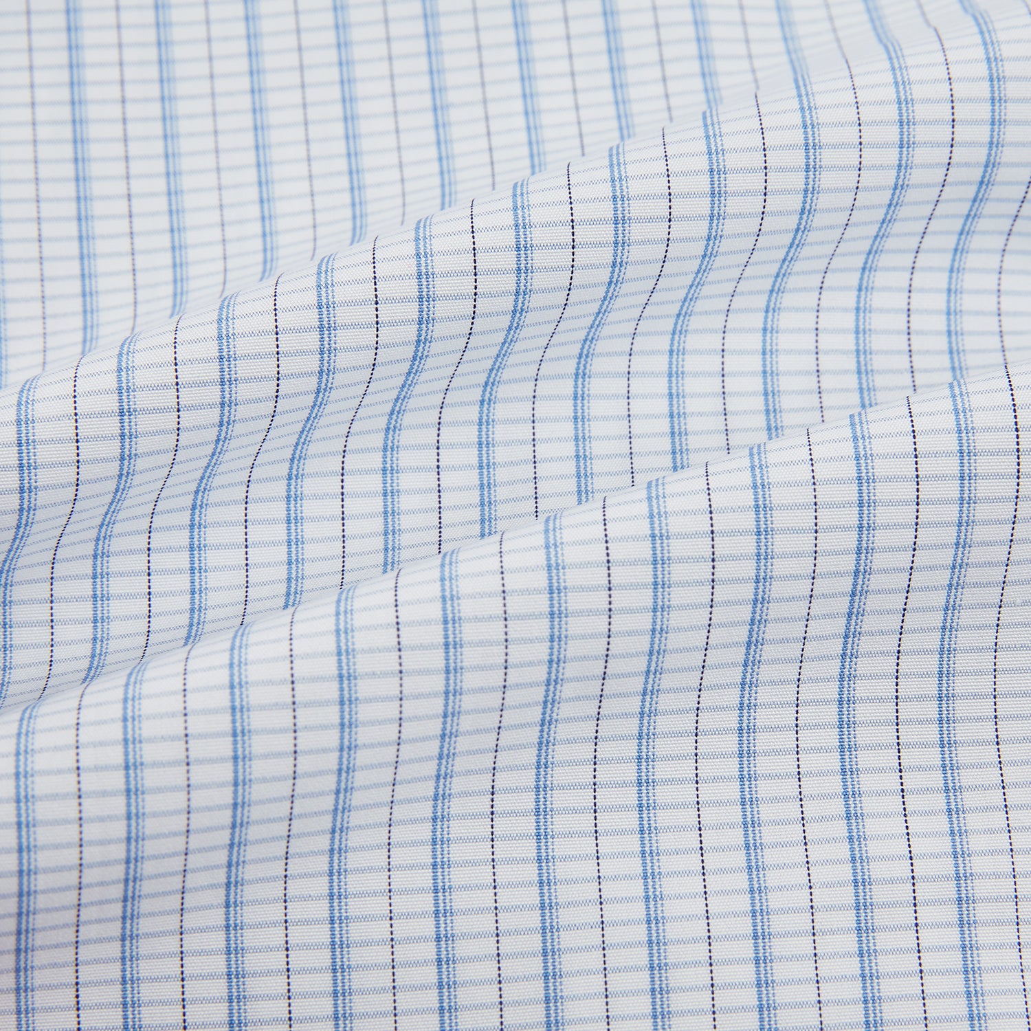 Image 6 of product The Turnbull & Asser Blue Graph Check Mayfair Shirt features a classic T&A collar, Mayfair fit, buttoned cuffs, and long sleeves with light blue graph checks on a white background.