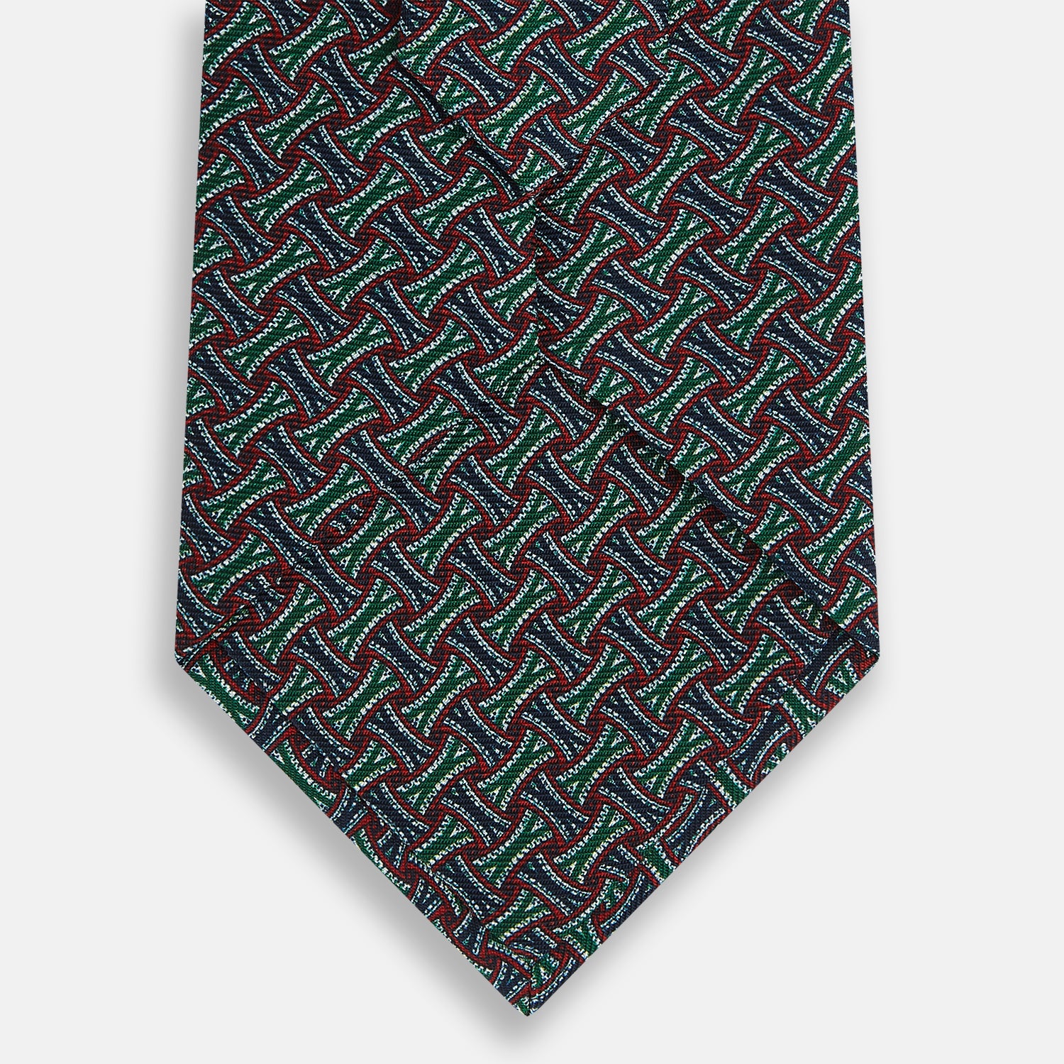 Image 3 of product The Forest Green and Red Weave Patterned Silk Tie by Turnbull & Asser features a geometric interlocking design in red, blue, and green, elegantly rolled on a white background.
