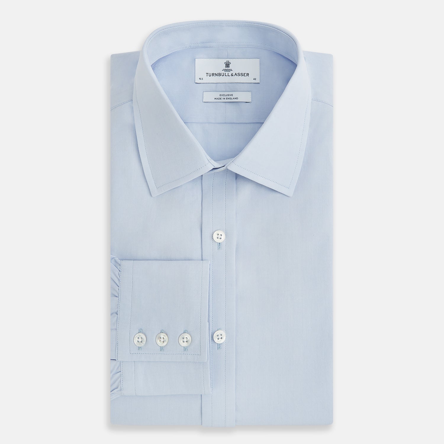 Image 5 of product The Pale Blue Mayfair Shirt by Turnbull & Asser is a long-sleeve, button-up dress shirt with a pointed collar and buttoned cuffs, crafted from sanforised cotton and shown laid flat on a white background.