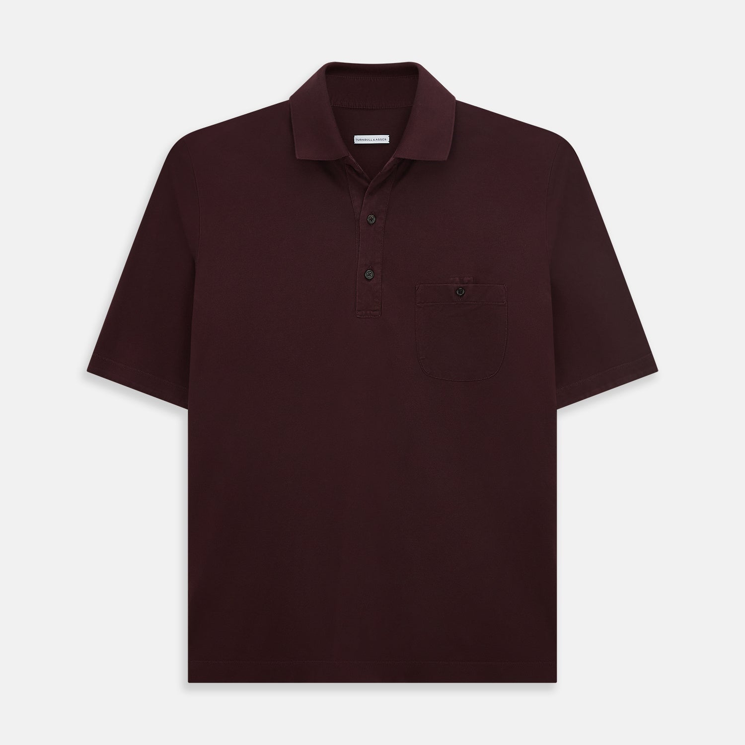 Image 1 of product The Turnbull & Asser Burgundy Polo Shirt is crafted from soft cotton jersey with short sleeves, a classic collar, three front buttons, and a small buttoned chest pocket, shown flat on a white background.