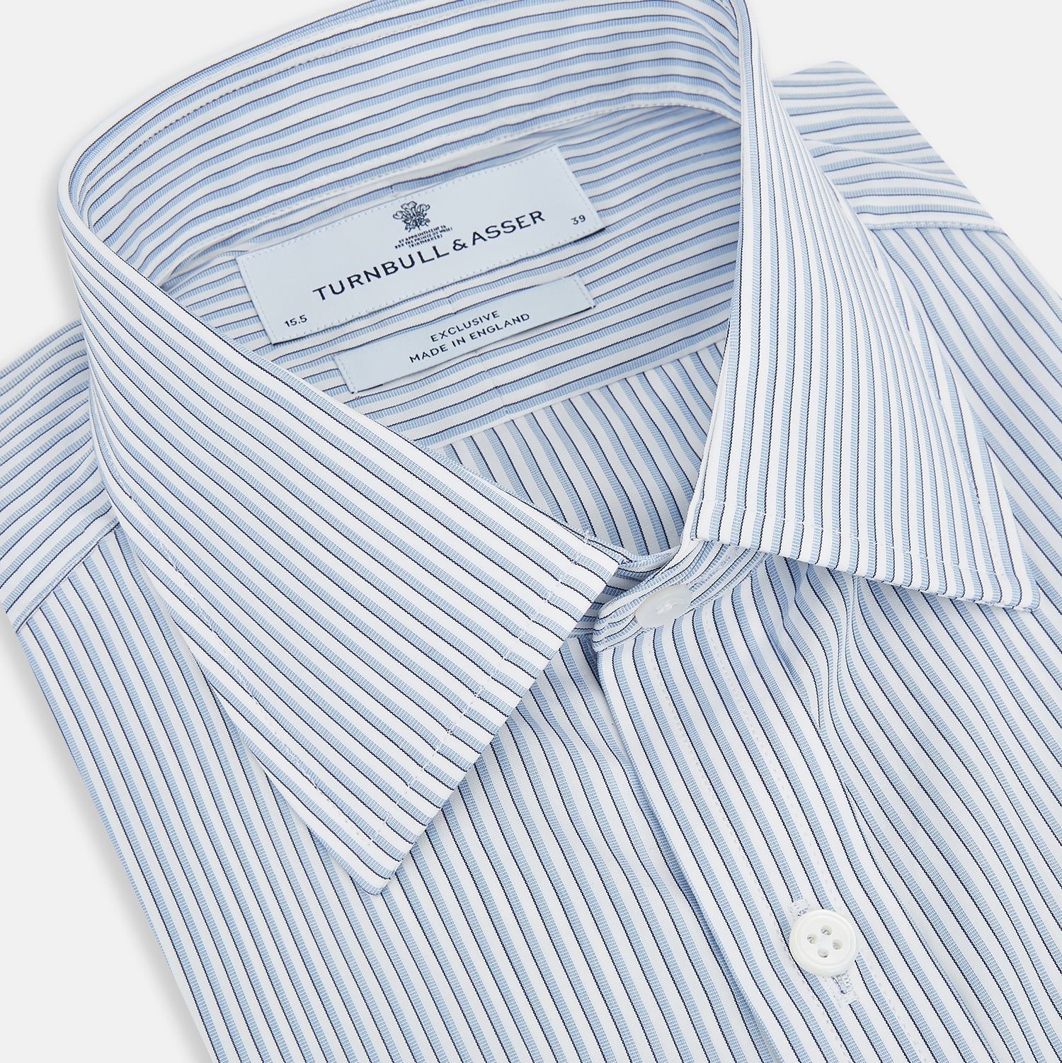 Image 2 of product The Turnbull & Asser Sky Blue Shadow Pinstripe Mayfair Shirt, a long-sleeved, button-up shirt with a T&A collar and light blue and white thin vertical stripes, is displayed flat on a white background.