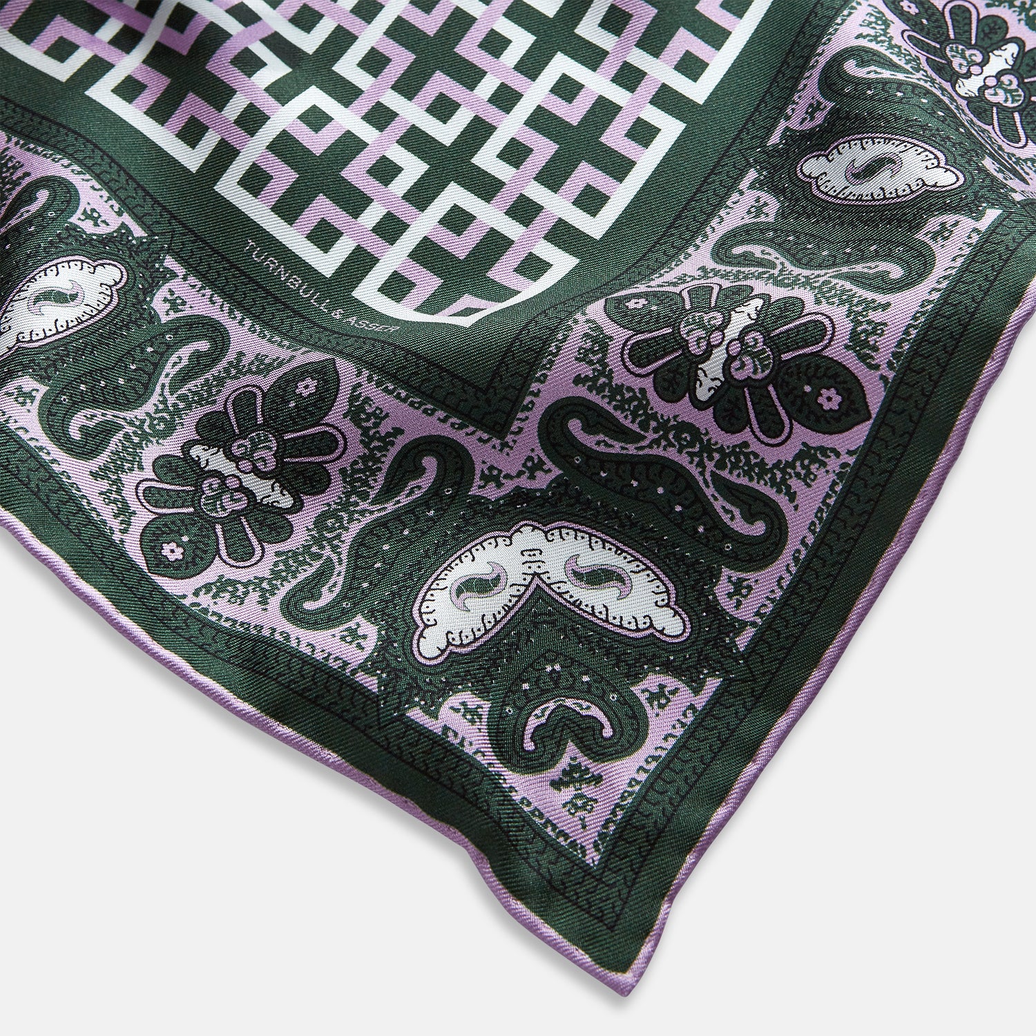 Image 7 of product The Forest Green Square-Patterned and Paisley Silk Pocket Square by Turnbull & Asser features geometric and paisley designs, is handcrafted in England, and has the brand printed near the edge.