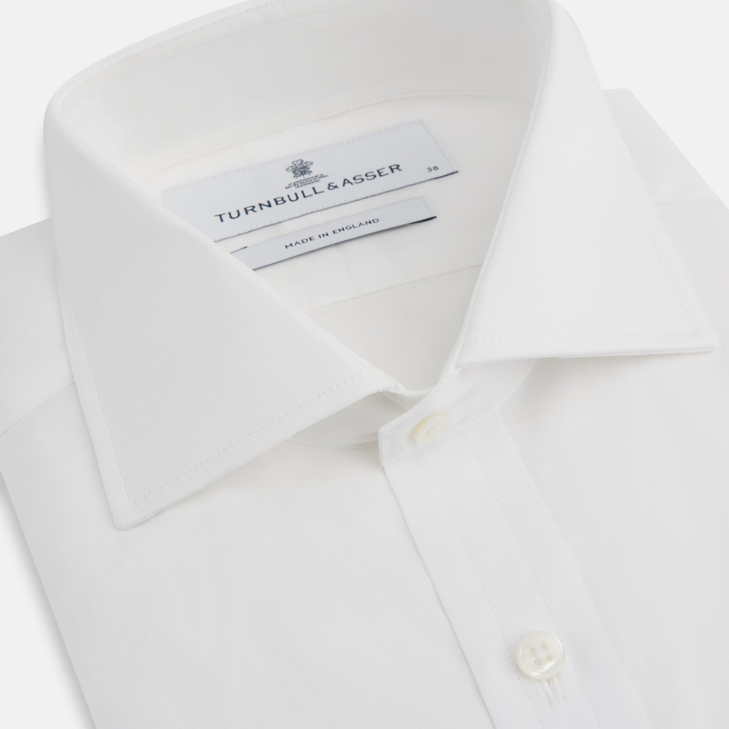 Image 2 of product The Turnbull & Asser White Poplin Shirt With Regent Collar and 2-Button Cocktail Cuffs, featuring long sleeves, is buttoned up and laid flat on a white background.