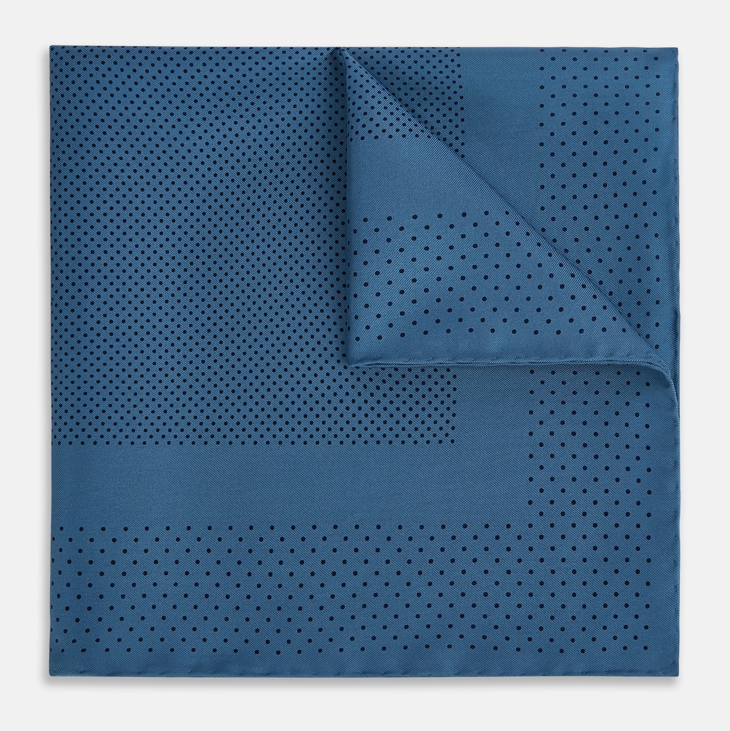 Image 1 of product The Blue Dot Silk Pocket Square by Turnbull & Asser features small black polka dots on blue silk and is made in England. The image shows it neatly folded, with a corner turned down to display both sides.