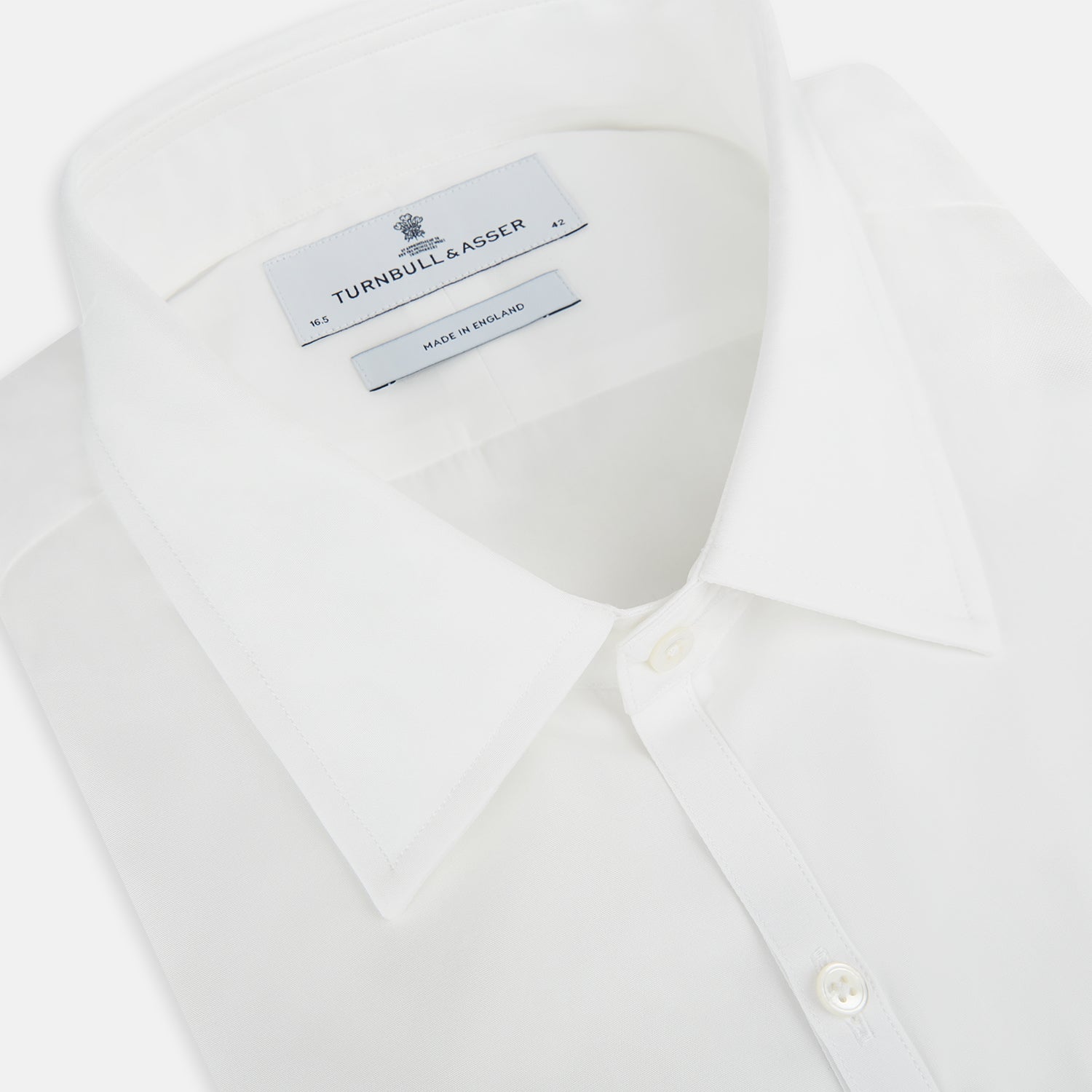 Image 2 of product The PLAIN WHITE WESTMINSTER SHIRT WITH TURNBULL COLLAR AND 3-BUTTON CUFFS by Turnbull & Asser features refined British craftsmanship, long sleeves, a straight hem, and a crisp white design displayed on a plain background.