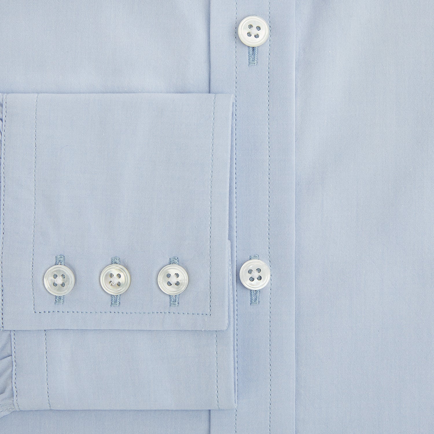 Image 4 of product The Pale Blue Mayfair Shirt by Turnbull & Asser is a long-sleeve, button-up dress shirt with a pointed collar and buttoned cuffs, crafted from sanforised cotton and shown laid flat on a white background.