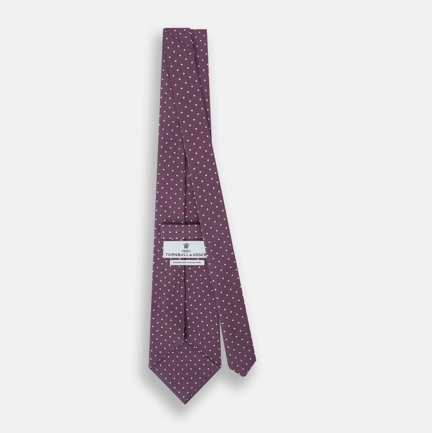Image 4 of product The Turnbull & Asser Lilac and Purple Micro Dot Silk Tie, featuring small white dots, is a stylish accessory for smart attire. Displayed rolled-up on a light background.