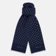 The Navy and White Spotted Silk Scarf by Turnbull & Asser features white polka dots, a fringed edge, and the brand's name printed near the bottom on both sides. It is neatly folded at the top.