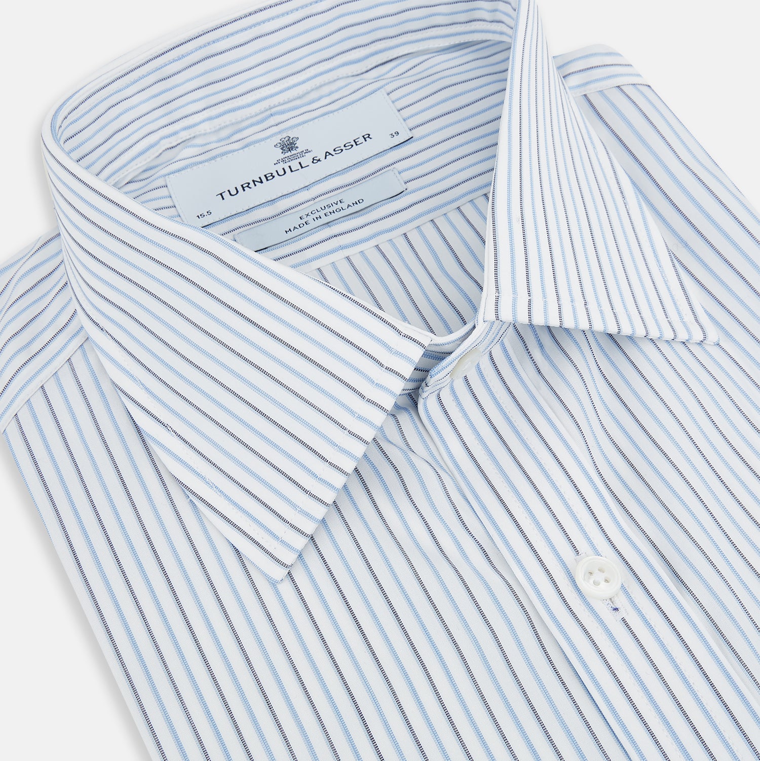 Image 2 of product The Turnbull & Asser Navy and Blue Shadow Stripe Mayfair Shirt, featuring a classic T&A collar and buttoned cuffs, is laid flat on a white background.