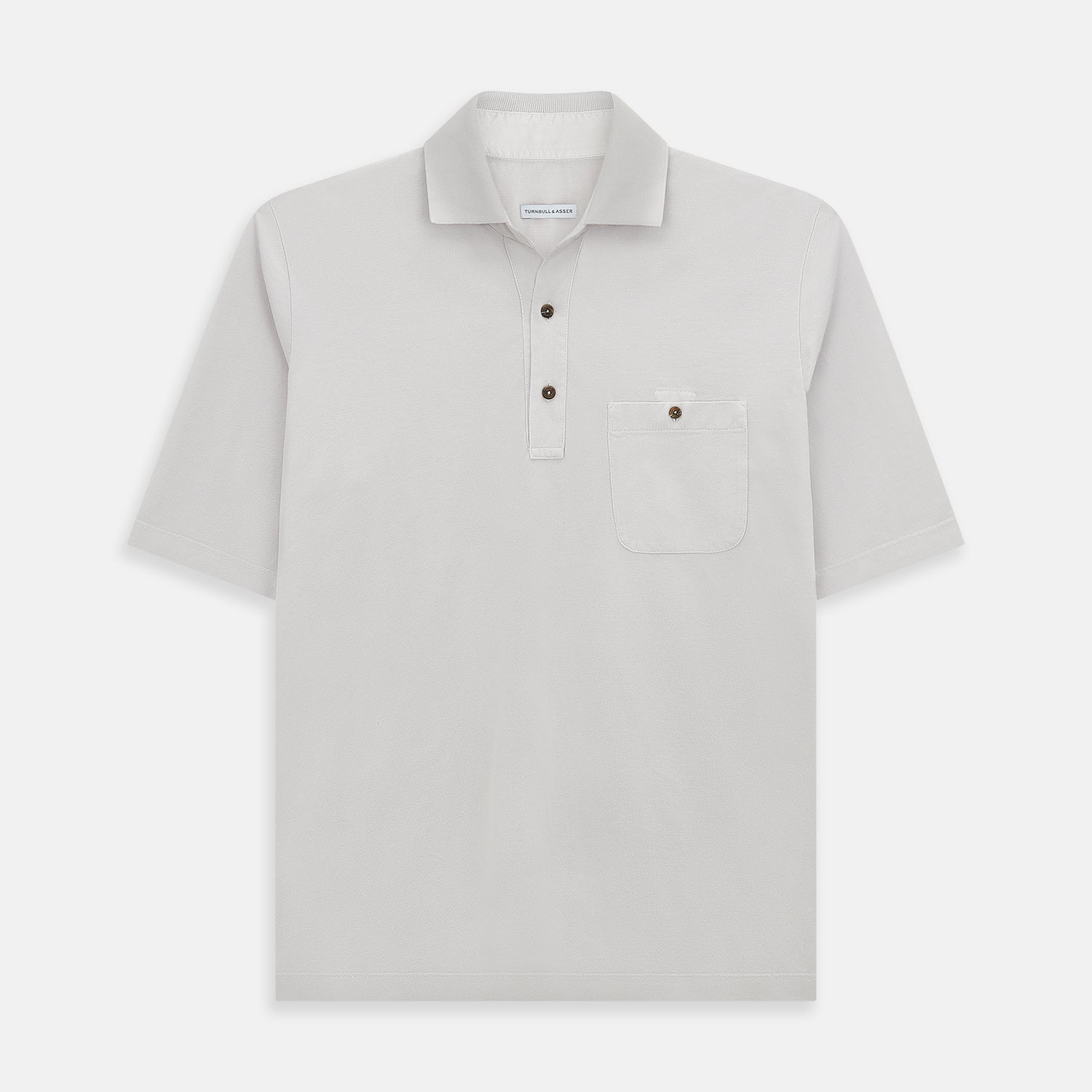 Image 1 of product The Turnbull & Asser Pale Pink Polo Shirt is a cotton jersey short-sleeve polo with a collar, three brown buttons on the placket, and a button-flap chest pocket, shown against a white background.