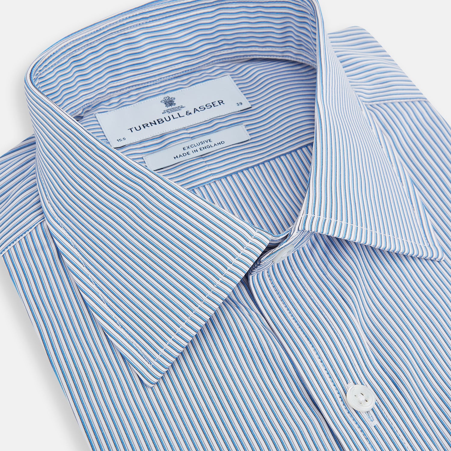 Image 2 of product The Turnbull & Asser Pale Blue Pinstripe Mayfair Shirt features pale blue pinstripes, a classic T&A collar, white buttons, and cuffed sleeves, shown against a plain white background.