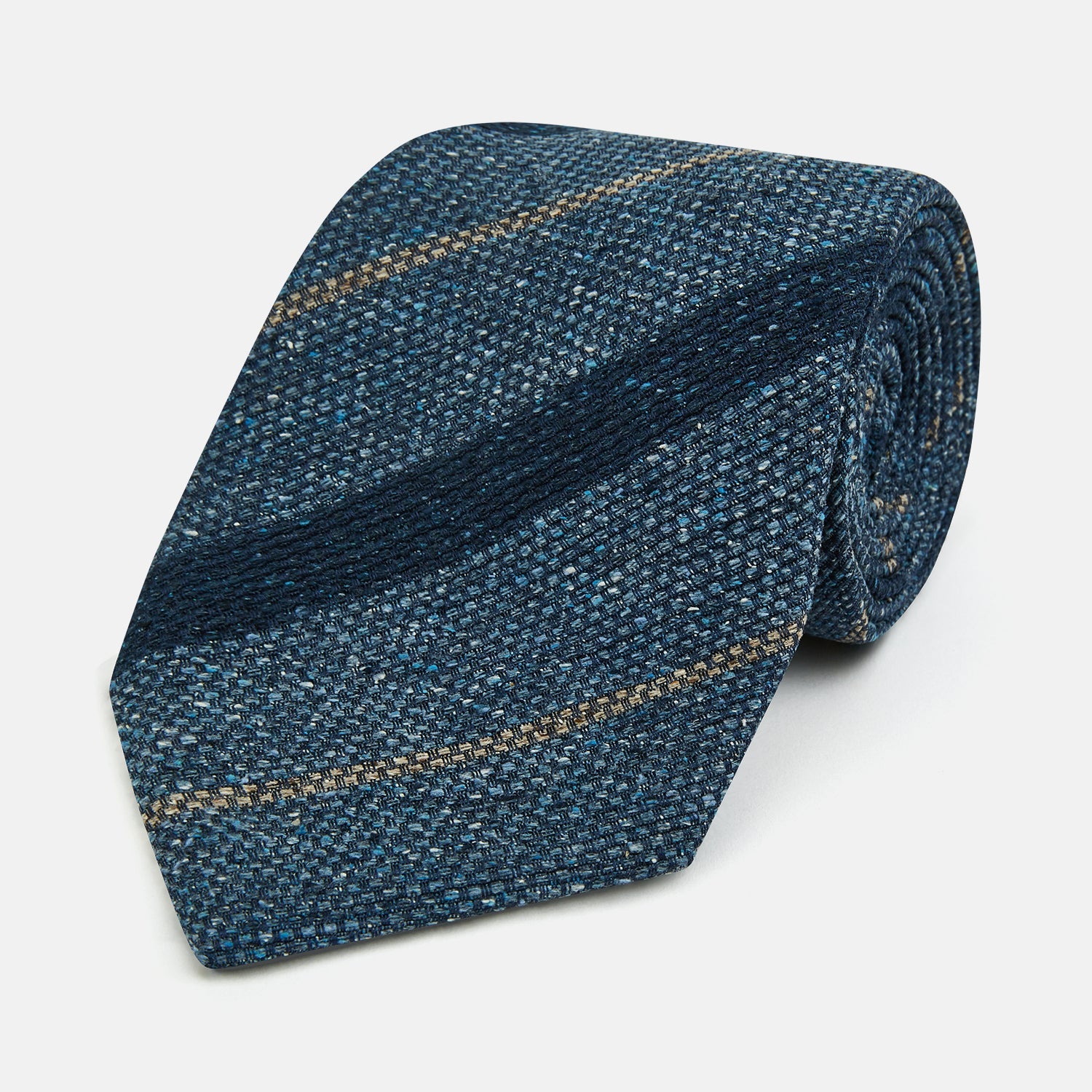 Image 1 of product The Blue Multi Stripe Silk Tie by Turnbull & Asser, featuring navy and cream stripes on blue English silk, is shown rolled up against a white background.