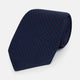 The Turnbull & Asser Navy and Red Polka Dot Silk Tie, rolled neatly on a light background, highlights classic British craftsmanship with its refined pattern.