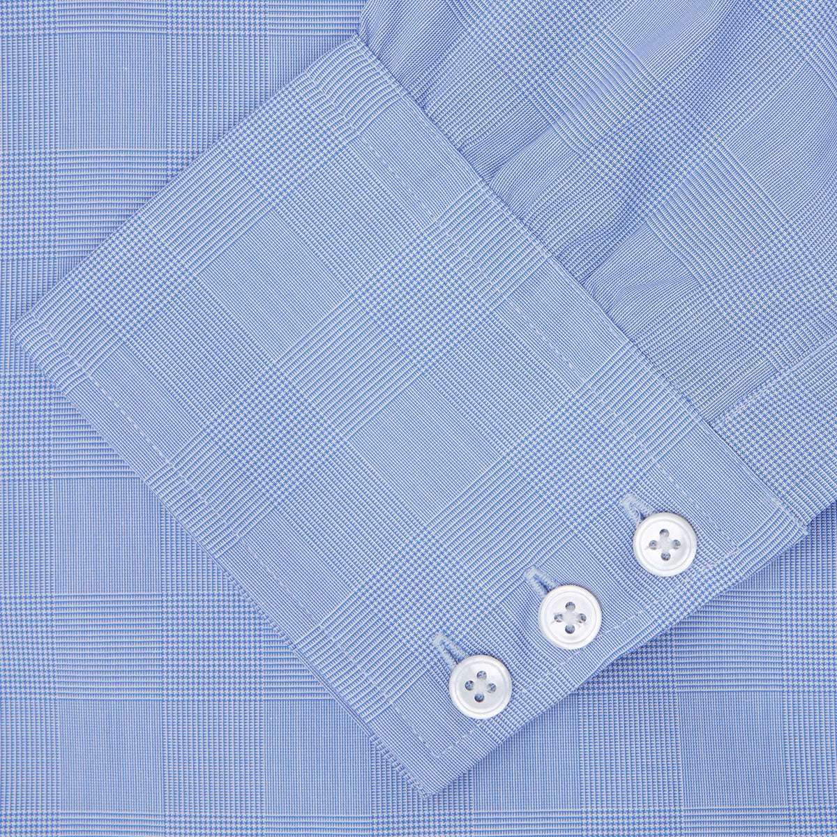 Image 3 of product A Blue Prince of Wales Check Shirt by Turnbull & Asser, featuring a T&A collar and 3-button cuffs, is neatly folded and displayed on a plain white background.