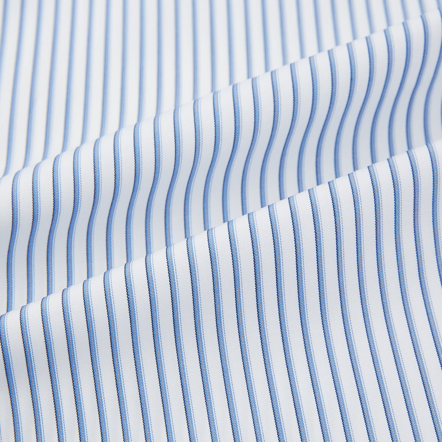 Image 6 of product The Turnbull & Asser Blue Shadow Stripe Mayfair Shirt is a long-sleeve button-up with a T&A collar and thin blue vertical stripes on white, shown on a plain white background.