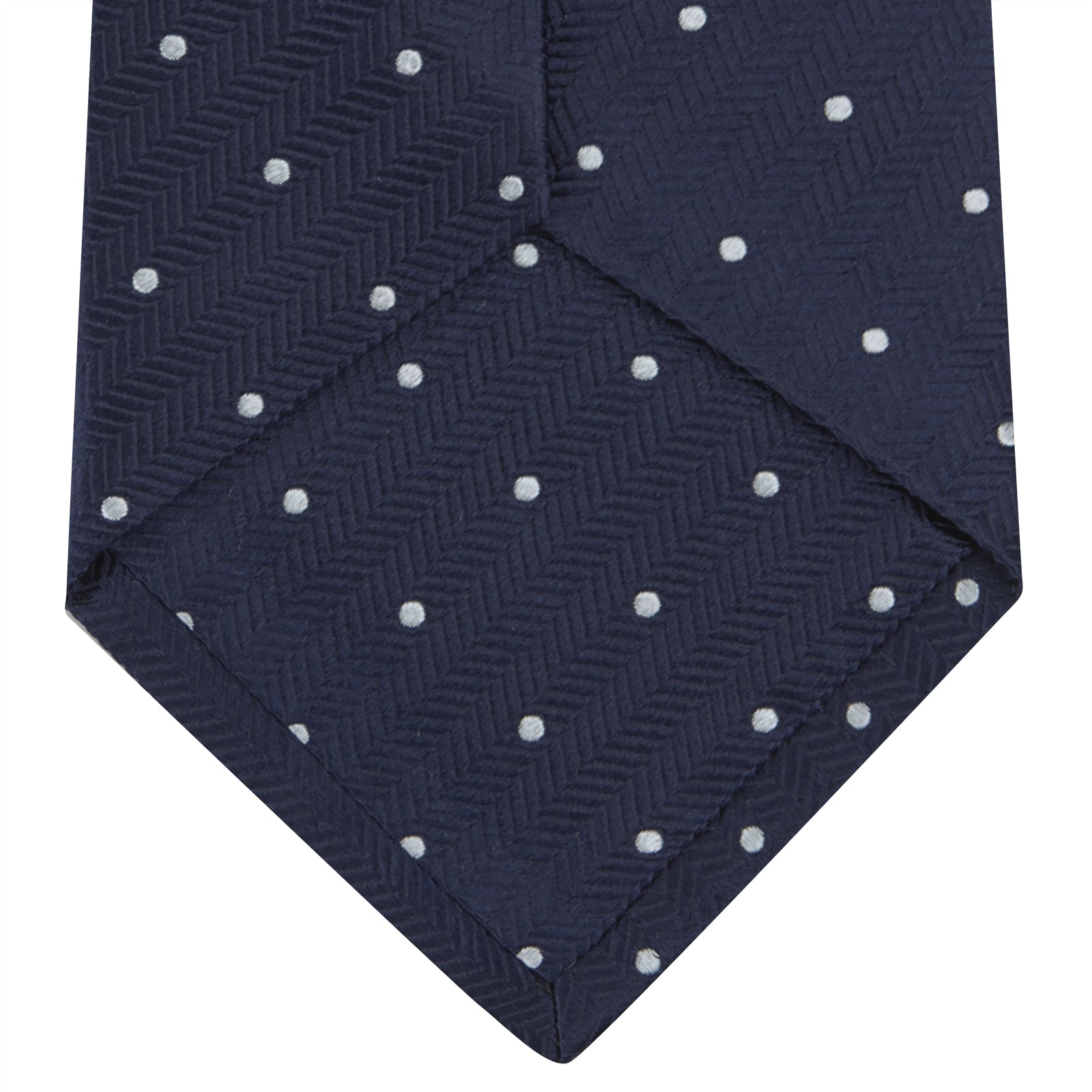 Image 4 of product The Navy and White Small Spot Herringbone Silk Tie from Turnbull & Asser features a classic navy herringbone pattern with small white polka dots, offering an elegant look suitable for any occasion.