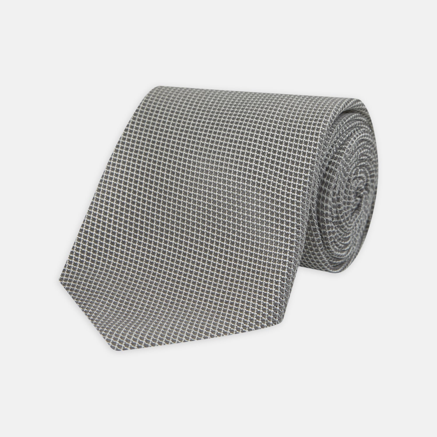 Image 1 of product The Turnbull & Asser Light Grey Grenadine Silk Tie features a finely textured checkered pattern and superb dimensional stability, shown rolled up against a plain white background.