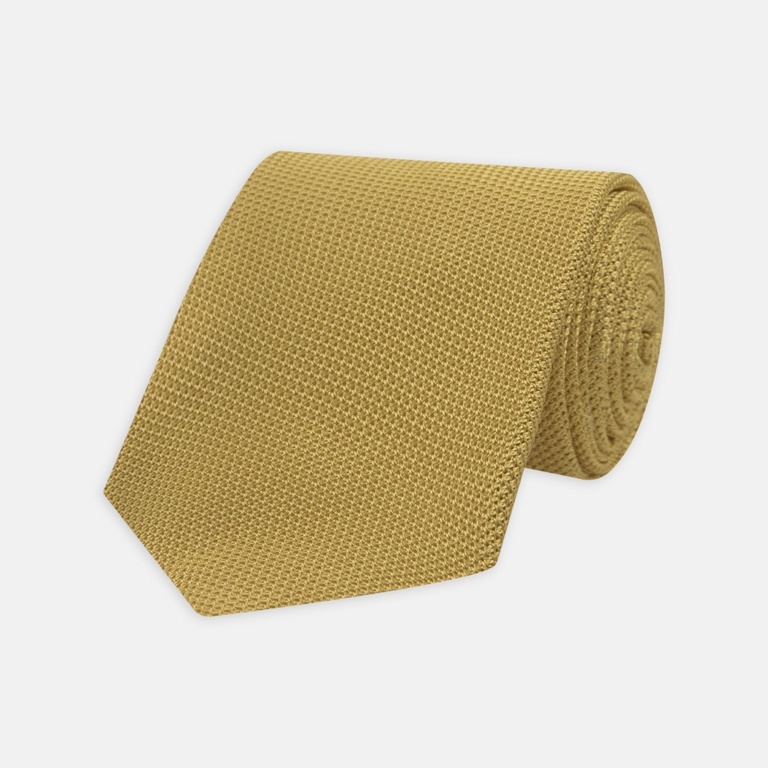 Image 1 of product The Turnbull & Asser Gold Grenadine Silk Tie, recognized for its dimensional stability, is shown rolled up against a plain white background.