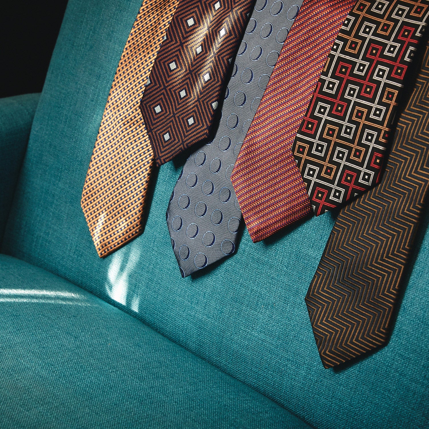 Image 6 of product The Turnbull & Asser "The World Is Not Enough" Square Silk Tie, as seen on James Bond, features a geometric diamond pattern in black, red, yellow, and white on gray—an ideal stylish gift for any Bond fan.