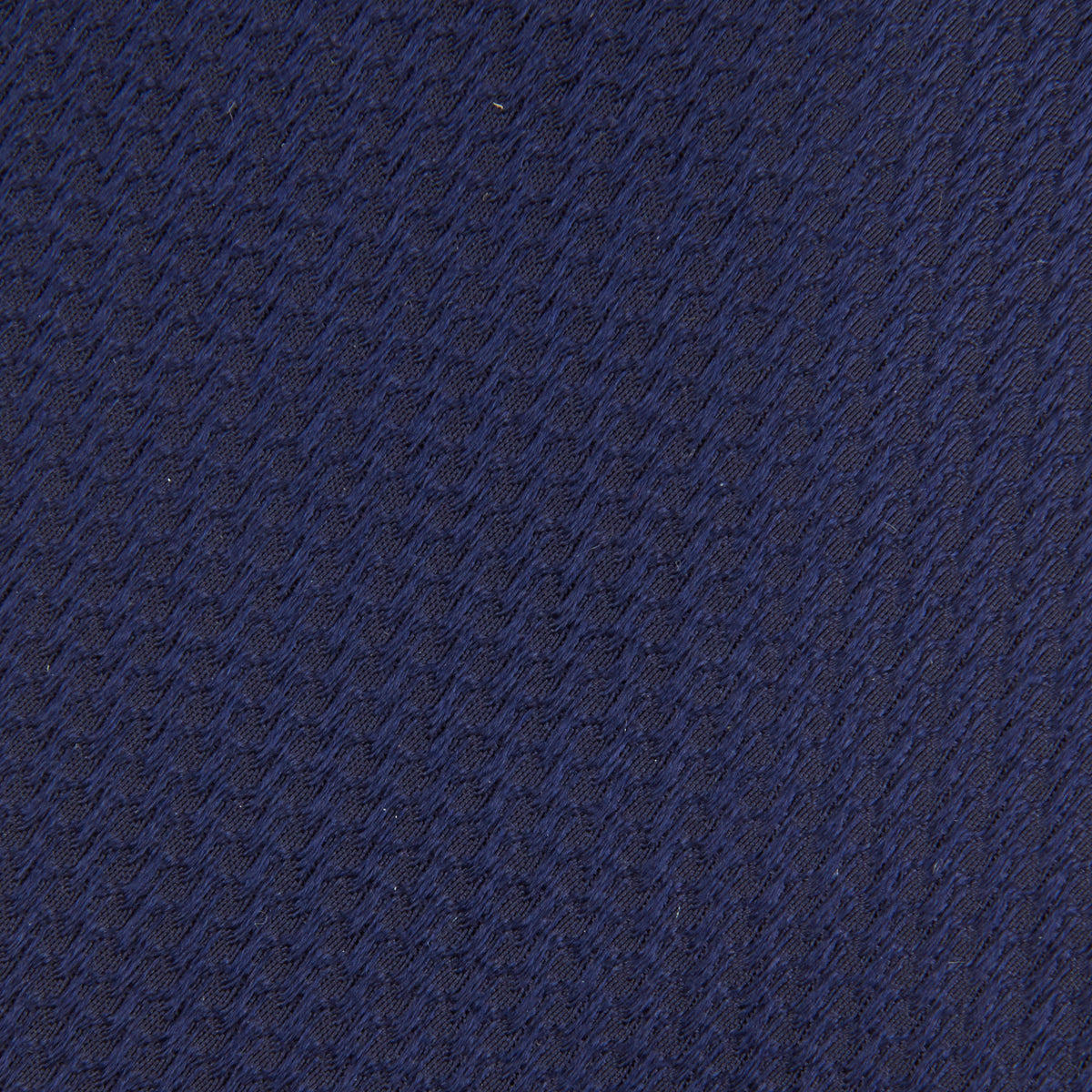 Image 3 of product The Turnbull & Asser Navy Lace Silk Tie, featuring a subtle lace weave texture, is displayed rolled up on a plain white background.
