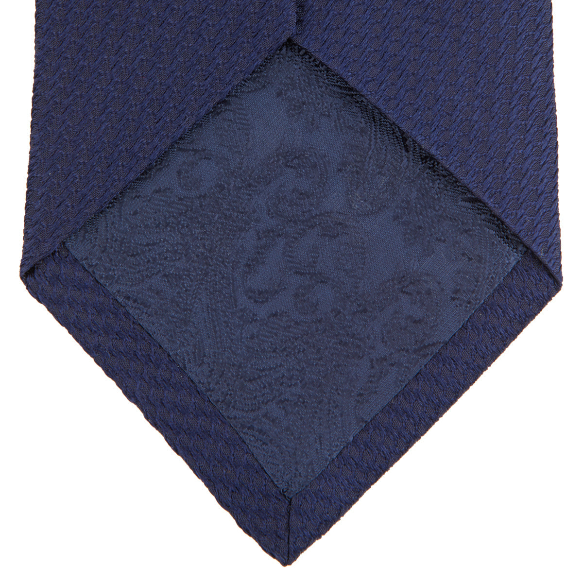 Image 4 of product The Turnbull & Asser Navy Lace Silk Tie, featuring a subtle lace weave texture, is displayed rolled up on a plain white background.