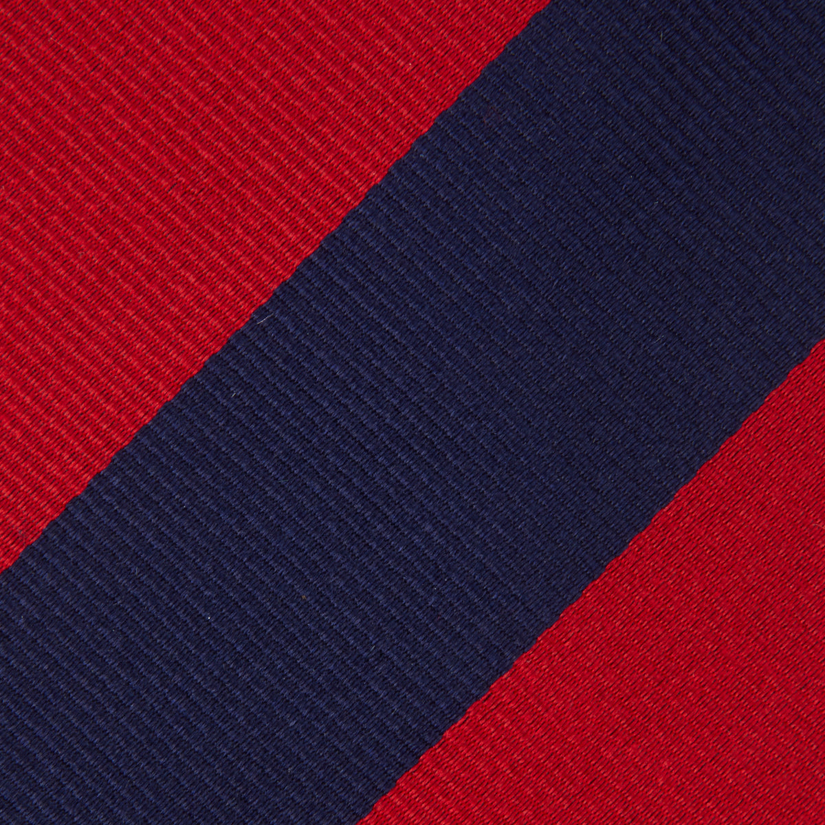 Image 3 of product The Navy and Red Block Stripe Repp Silk Tie by Turnbull & Asser features bold diagonal red and navy stripes on a crisp white background.