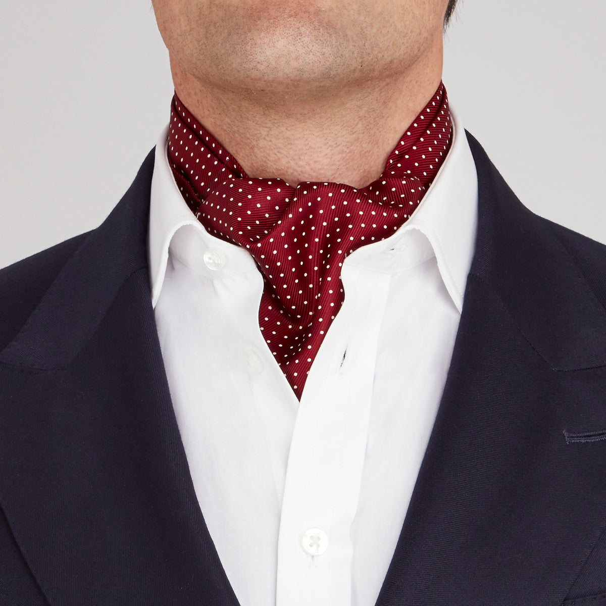 Image 2 of product The Burgundy and White Mini Spot Silk Cravat by Turnbull & Asser adds refined detail—ideal neckwear for wedding guests, especially paired with a matching maroon pocket square.