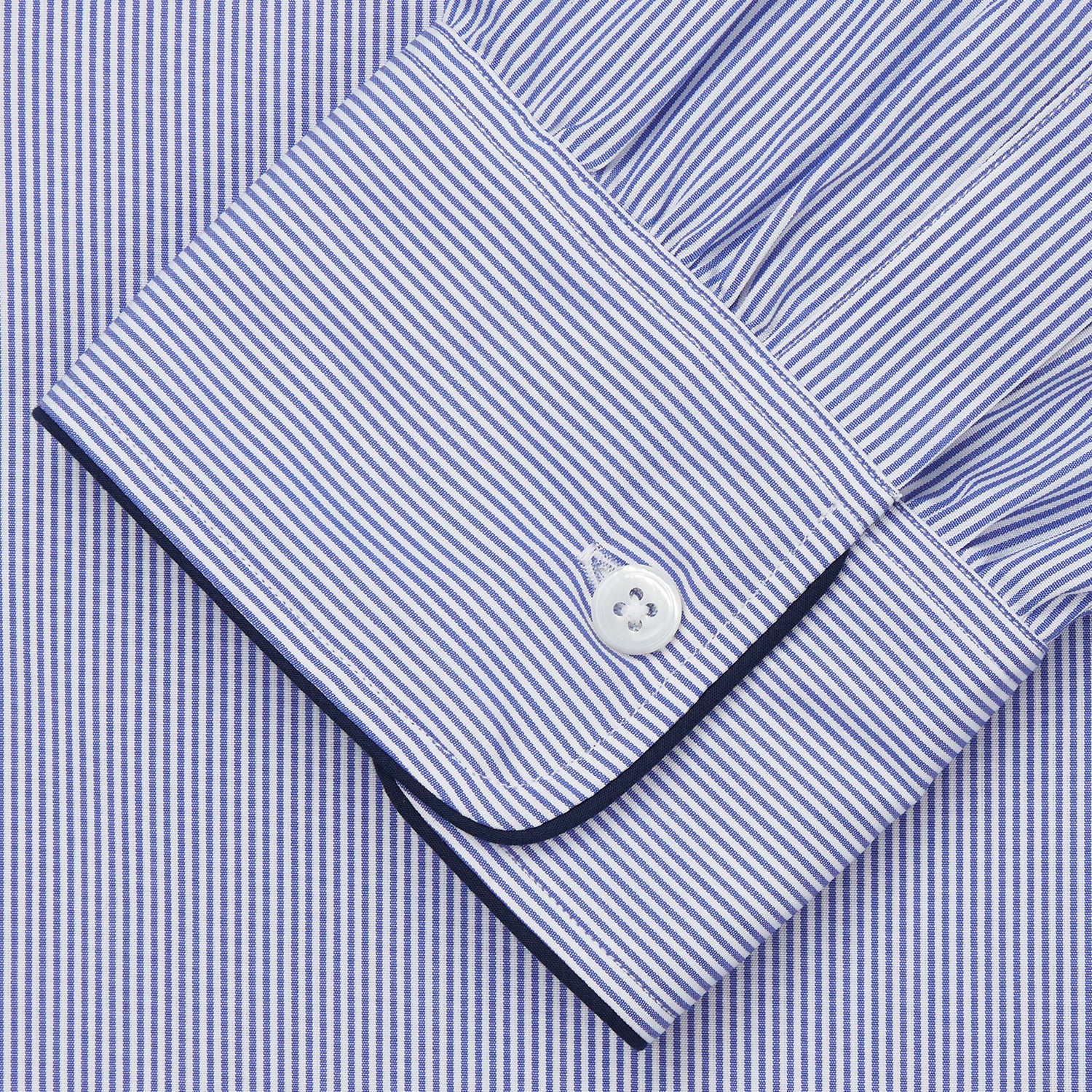 Image 3 of product The Turnbull & Asser Blue Fine Bengal Stripe Piped Cotton Nightshirt features long sleeves, a chest pocket, black collar piping, curved hem, and side slits. It is displayed laid flat on a white background.