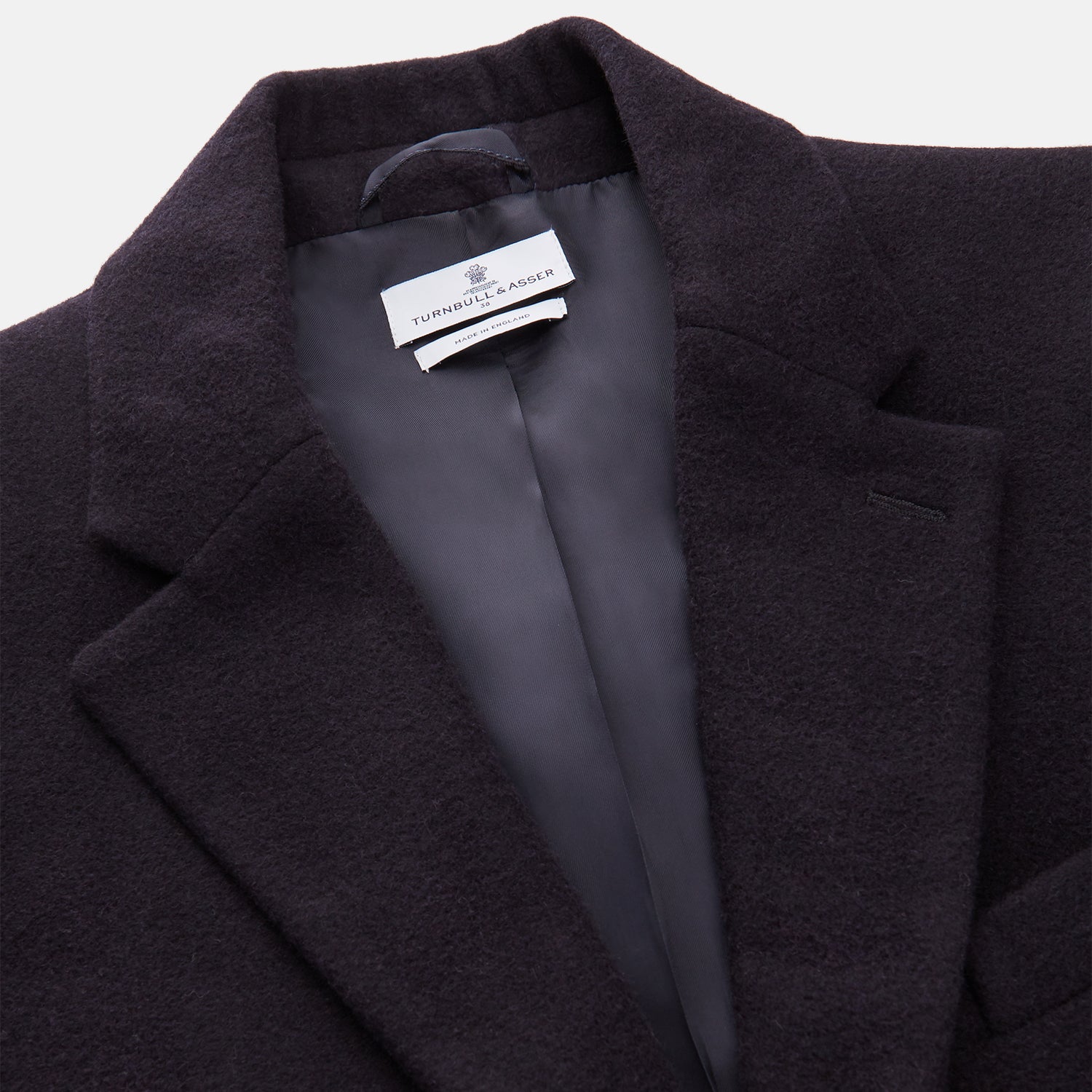 Image 3 of product The Turnbull & Asser Navy Cashmere Joseph Overcoat features notched lapels, three front pockets, buttoned cuffs, and a hidden button closure—an essential men’s outerwear piece shown against a plain white background.