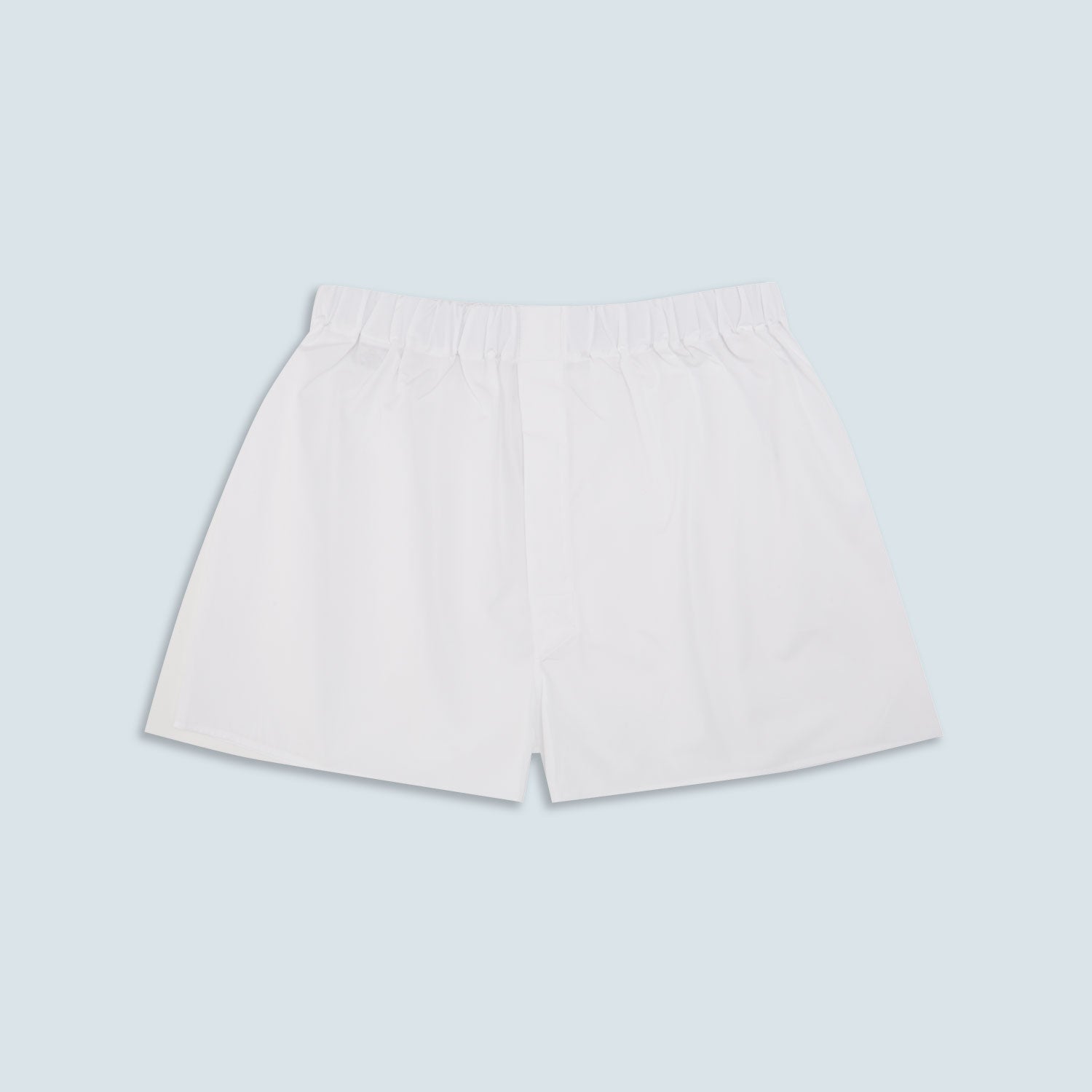 Image 1 of product Turnbull & Asser’s White Sea Island Quality Cotton Boxer Shorts, shown flat on a light blue background, offer luxurious comfort with an elastic waistband—a premium underwear choice.