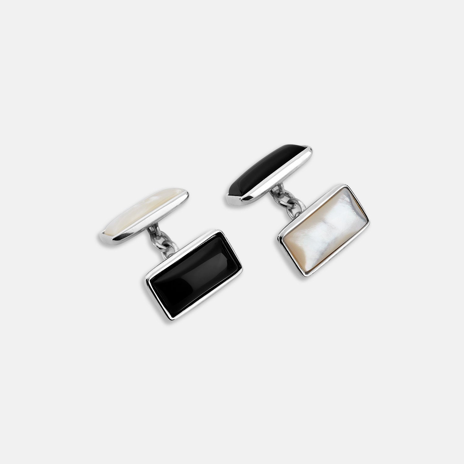 Image 1 of product Turnbull & Asser's Reversible Monochrome Sterling Silver Rectangular Cufflinks feature black onyx on one side and white mother-of-pearl on the other, shown against a plain light gray background.