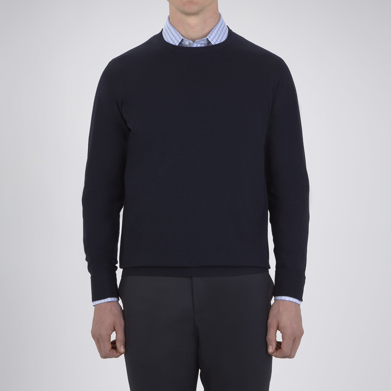 Image 2 of product A neatly folded Indigo Crew Neck Merino Wool Jumper by Turnbull & Asser, featuring a visible brand label at the collar and one sleeve tucked across the front, displayed on a white background—a versatile staple for any gentleman's wardrobe.