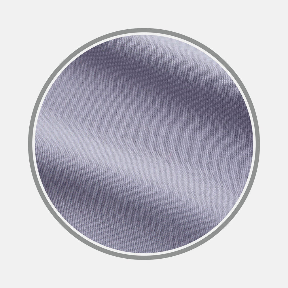 Close-up of Turnbull & Asser’s BESPOKE FABRIC 0033 18—a smooth, light gray fabric with a subtle sheen and diagonal weave—ideal for custom shirts, shown in a circular frame on a light background.