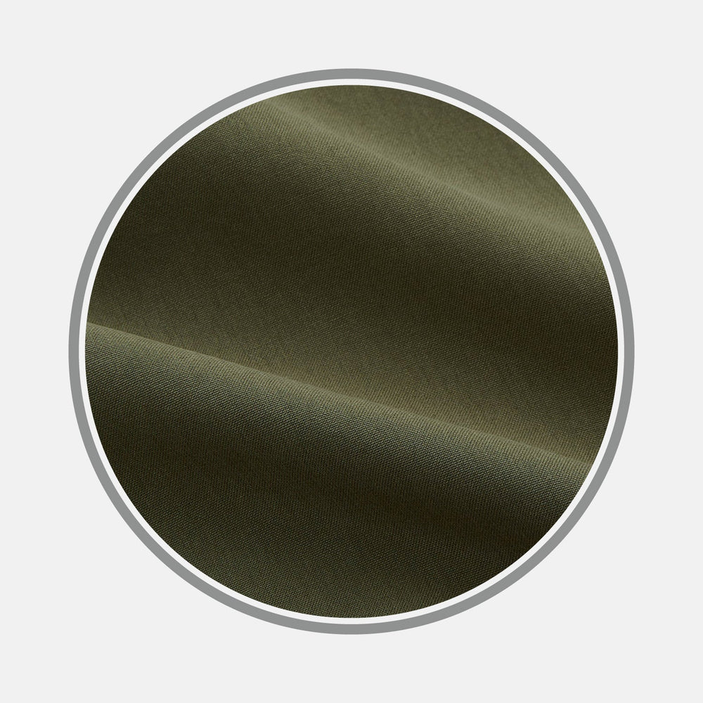 Close-up of BESPOKE FABRIC 0033 47 by Turnbull & Asser: olive green fabric with a smooth texture, soft folds, and gentle shadows, ideal for custom shirts. Displayed in a circular frame on a light gray background.