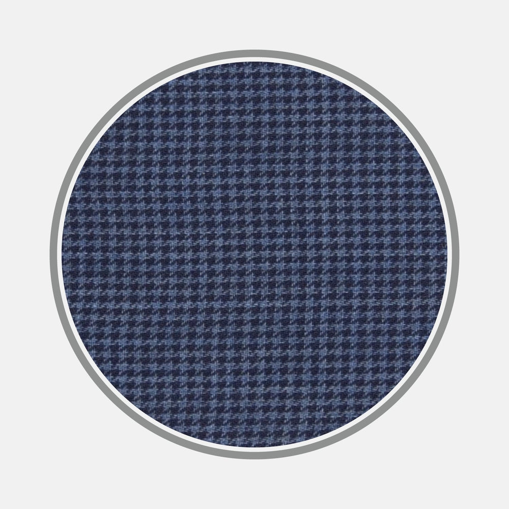 Close-up of Turnbull & Asser's BESPOKE FABRIC 0093 30, highlighting a blue and navy houndstooth weave for bespoke shirts, shown within a circular frame on a light gray background.