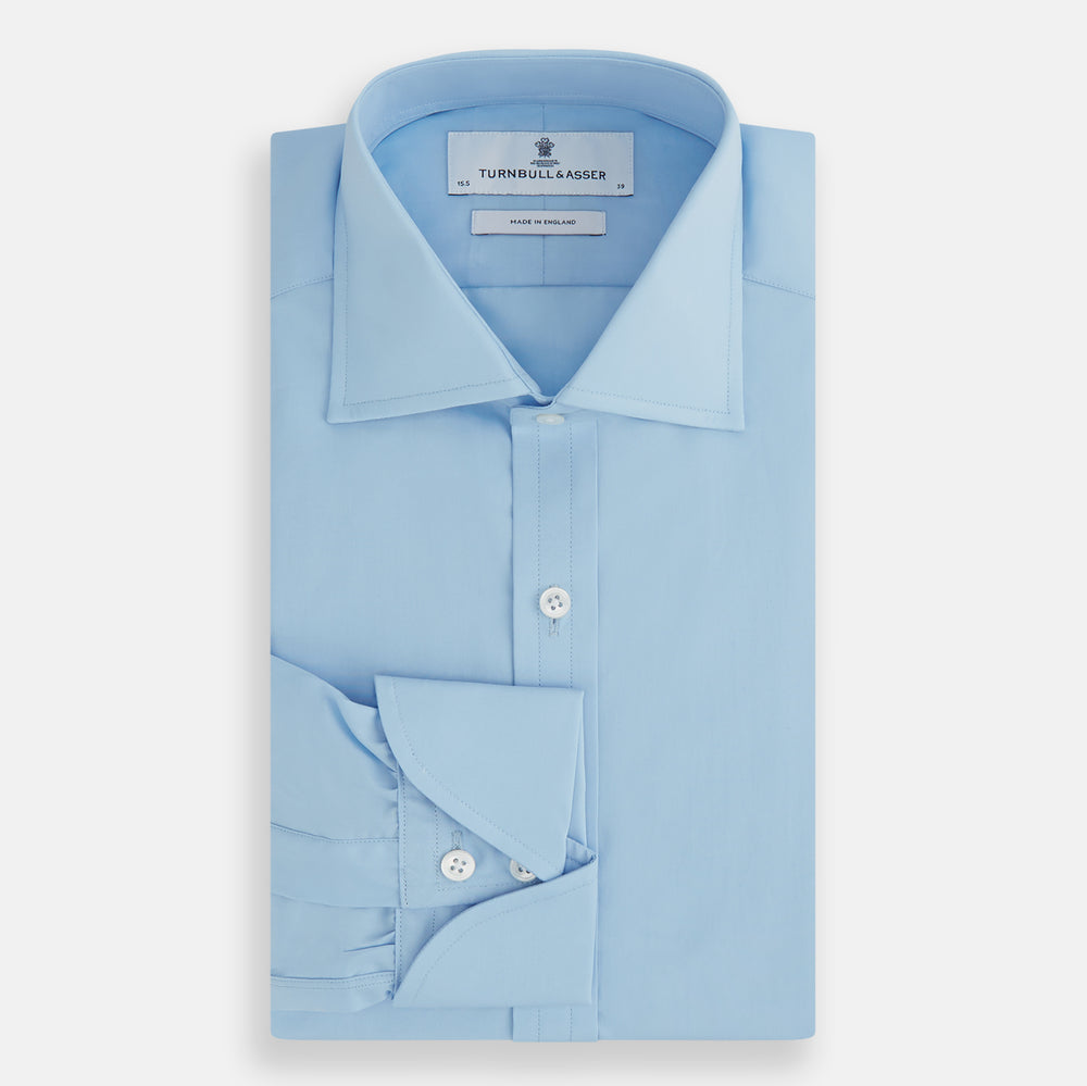 The Turnbull & Asser Dr. No Blue Cotton Shirt with a classic collar, cocktail cuffs, button-up front, and straight hem is featured on a plain white background. As seen on James Bond.