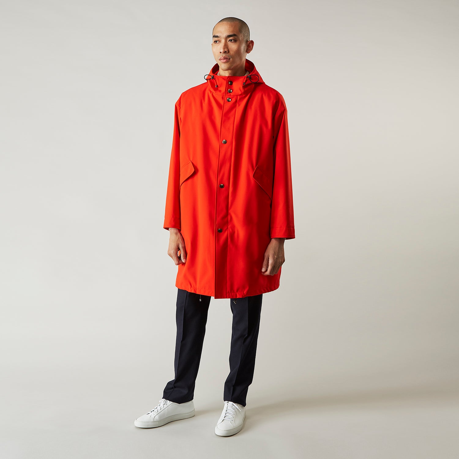 View 3 of product Wearing the Turnbull & Asser Red Walter Sealup Parka with Detachable Liner, black pants, and white sneakers, a person stands in profile against a plain light background—perfect for travel.