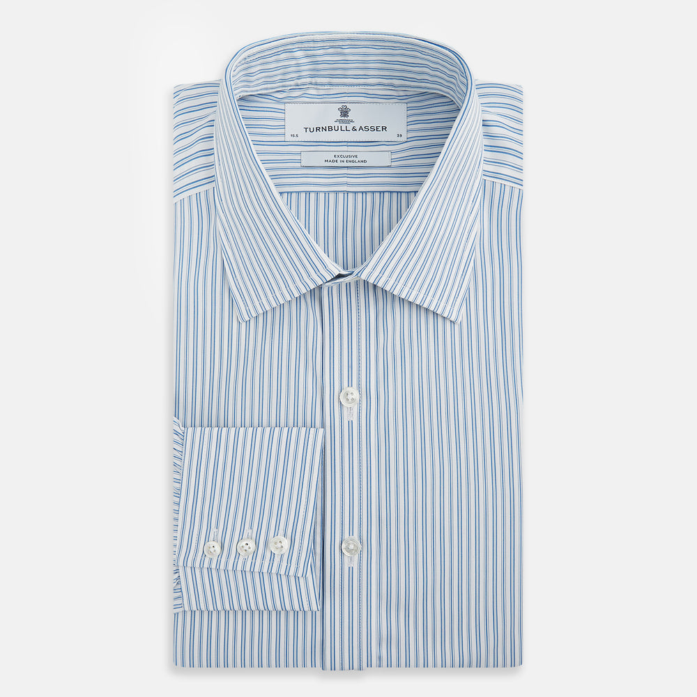 The Turnbull & Asser Sky Blue Double Stripe Mayfair Shirt features sky blue and white vertical stripes, a T&A collar, buttoned cuffs, and is displayed flat on a white background.