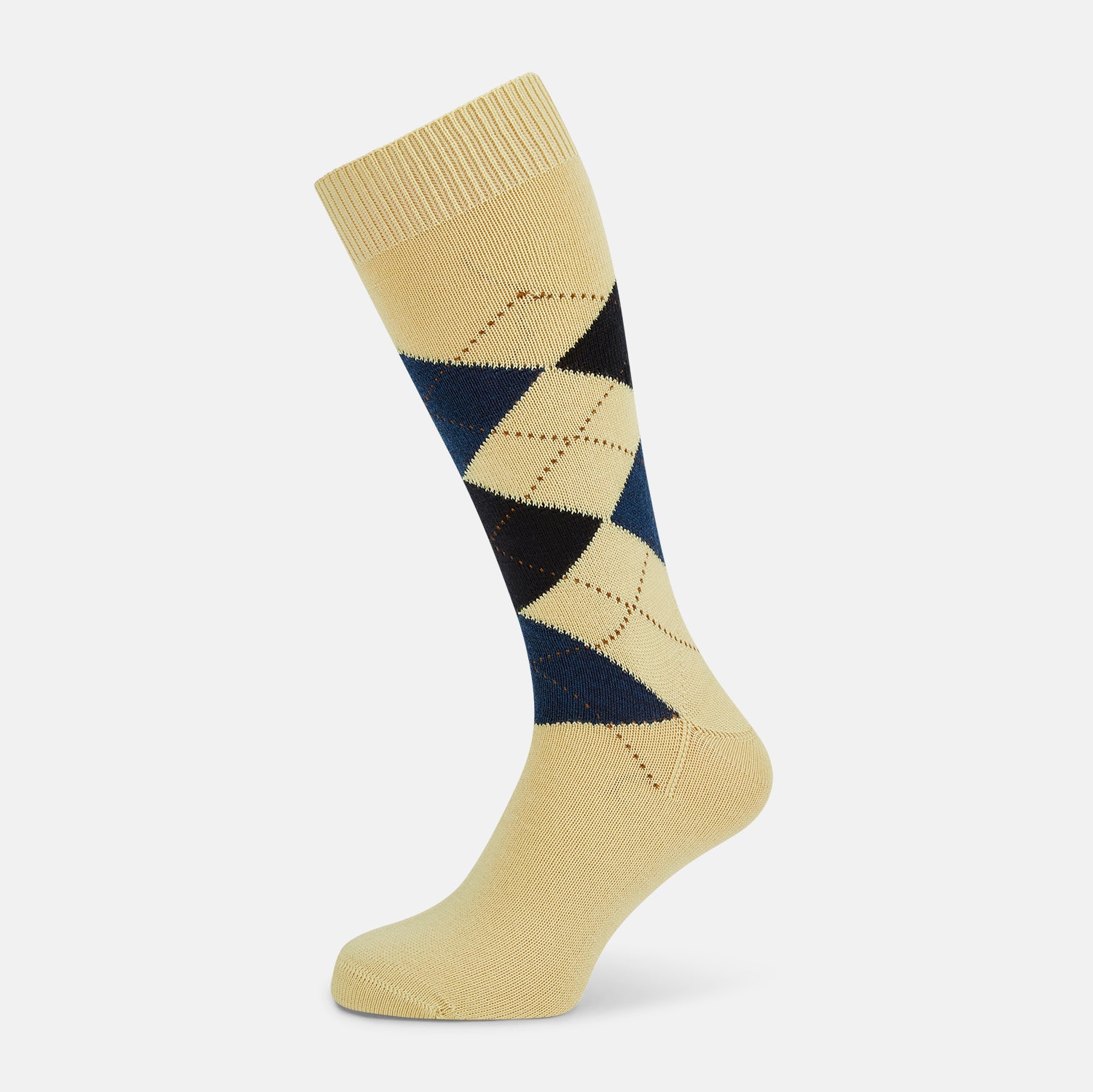View 1 of product The Turnbull & Asser Vanilla Wool Check Mid-Length Sock is beige with blue, black, and white argyle diamonds on the side and solid beige toe, heel, and cuff. Displayed on a plain white background.