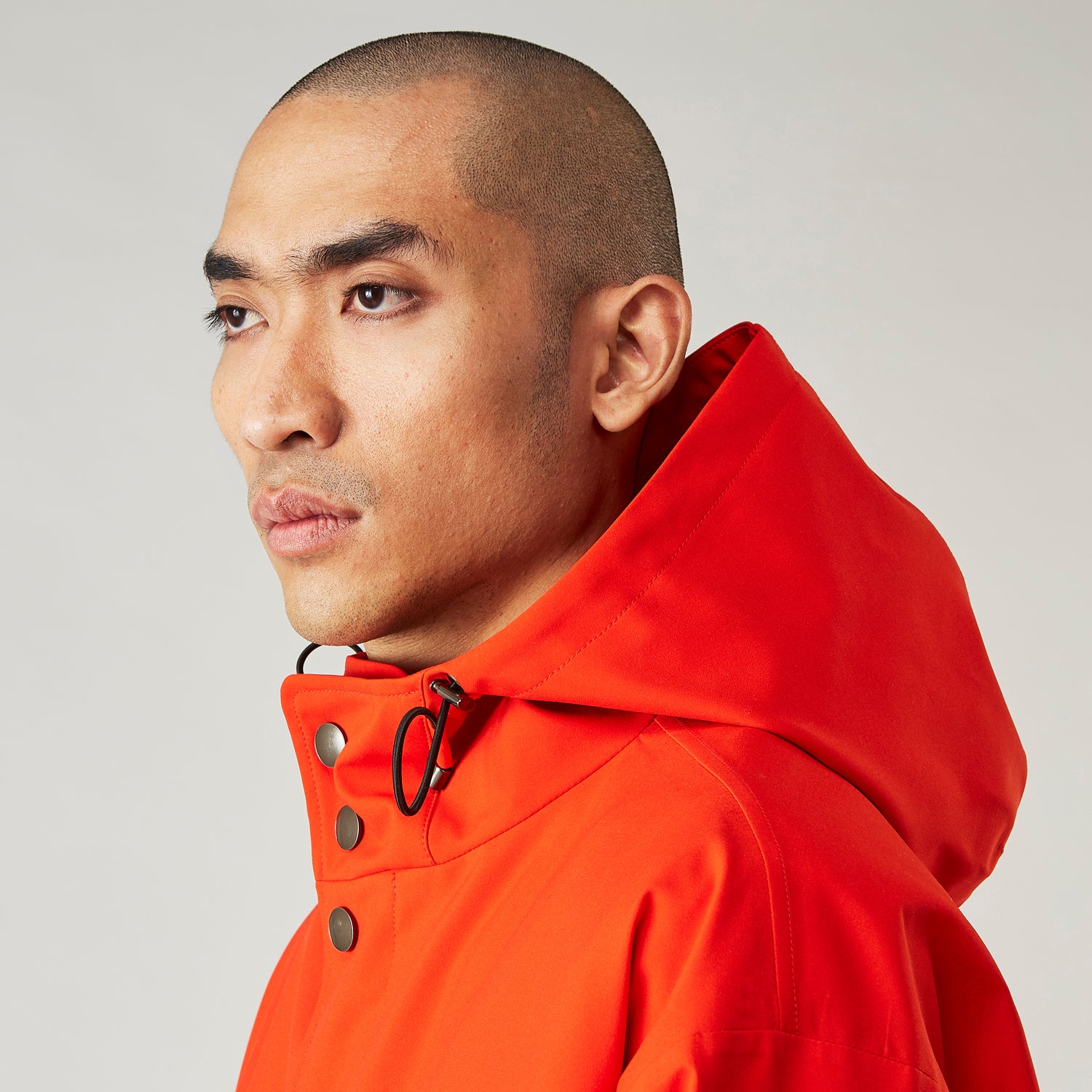 View 11 of product Wearing the Turnbull & Asser Red Walter Sealup Parka with Detachable Liner, black pants, and white sneakers, a person stands in profile against a plain light background—perfect for travel.