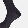 View 4 of product The Turnbull & Asser Smoke Mid-Length Sock, in black with a ribbed design, is displayed upright on a white background to highlight its refined comfort and coverage from toe to cuff.