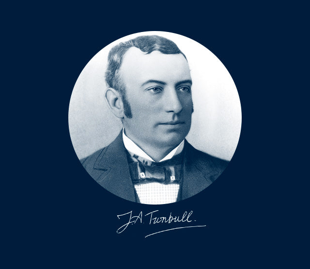 A sepia-toned portrait of a man in a suit with a bow tie and sideburns, shown within a circular frame. Below the portrait is a cursive signature reading J.A. Turnbull.