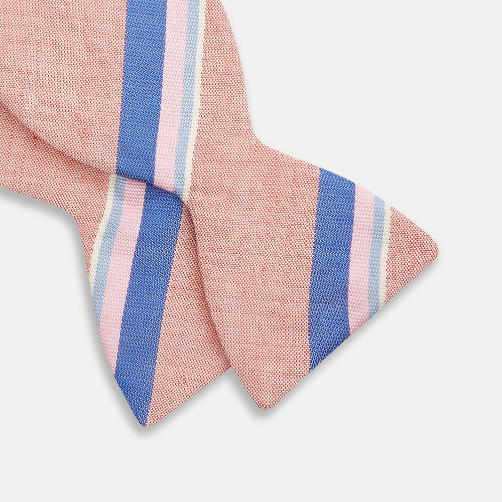 The Thistle-Petersham-Double End Bow Tie by Turnbull & Asser features a pink base with diagonal blue, white, and navy stripes—a versatile accessory perfect for any gentleman's wardrobe.