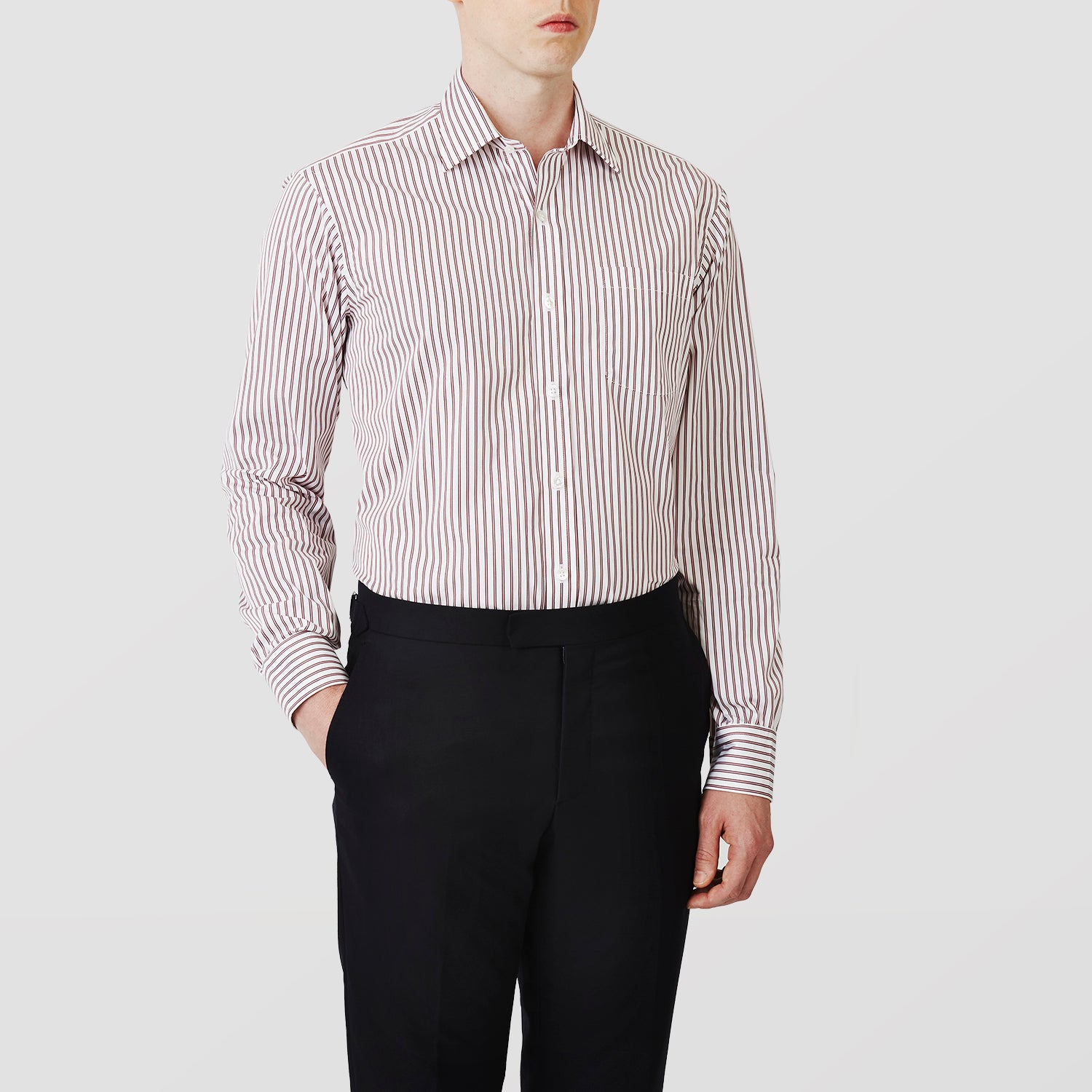 View 2 of product The Turnbull & Asser Burgundy Stripe Weekend Fit Shirt features a Derby collar, 1-button cuffs, and vertical burgundy and white stripes, shown laid flat on a plain light background.