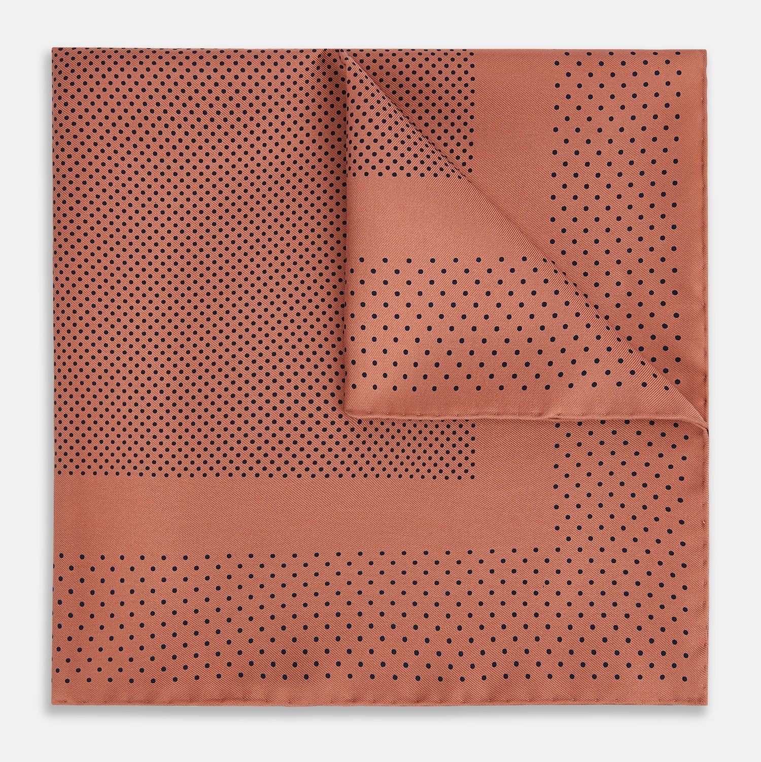 View 1 of product The Turnbull & Asser Blush Dot Silk Pocket Square features a rust hue with black polka dots, a bordered design, and hand-rolled edges, shown folded against a white background.
