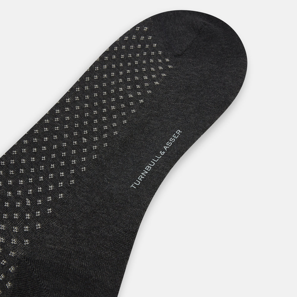 Turnbull & Asser Grey Motif Mid-Length Sock, crafted from Egyptian cotton, features a fine white geometric dot pattern on grey with a solid black cuff, heel, and toe for classic style. Displayed on a white background.