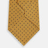 View 3 of product The Turnbull & Asser Navy and Yellow Micro Dot Silk Tie features evenly spaced dark blue micro dots on yellow silk, rolled and displayed on a white background—an elegant accessory for any occasion.