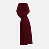 View 1 of product The Burgundy Rib-Knit Cashmere Scarf by Turnbull & Asser is crossed at the center and set against a plain light gray background—an elegant, luxurious winter accessory.